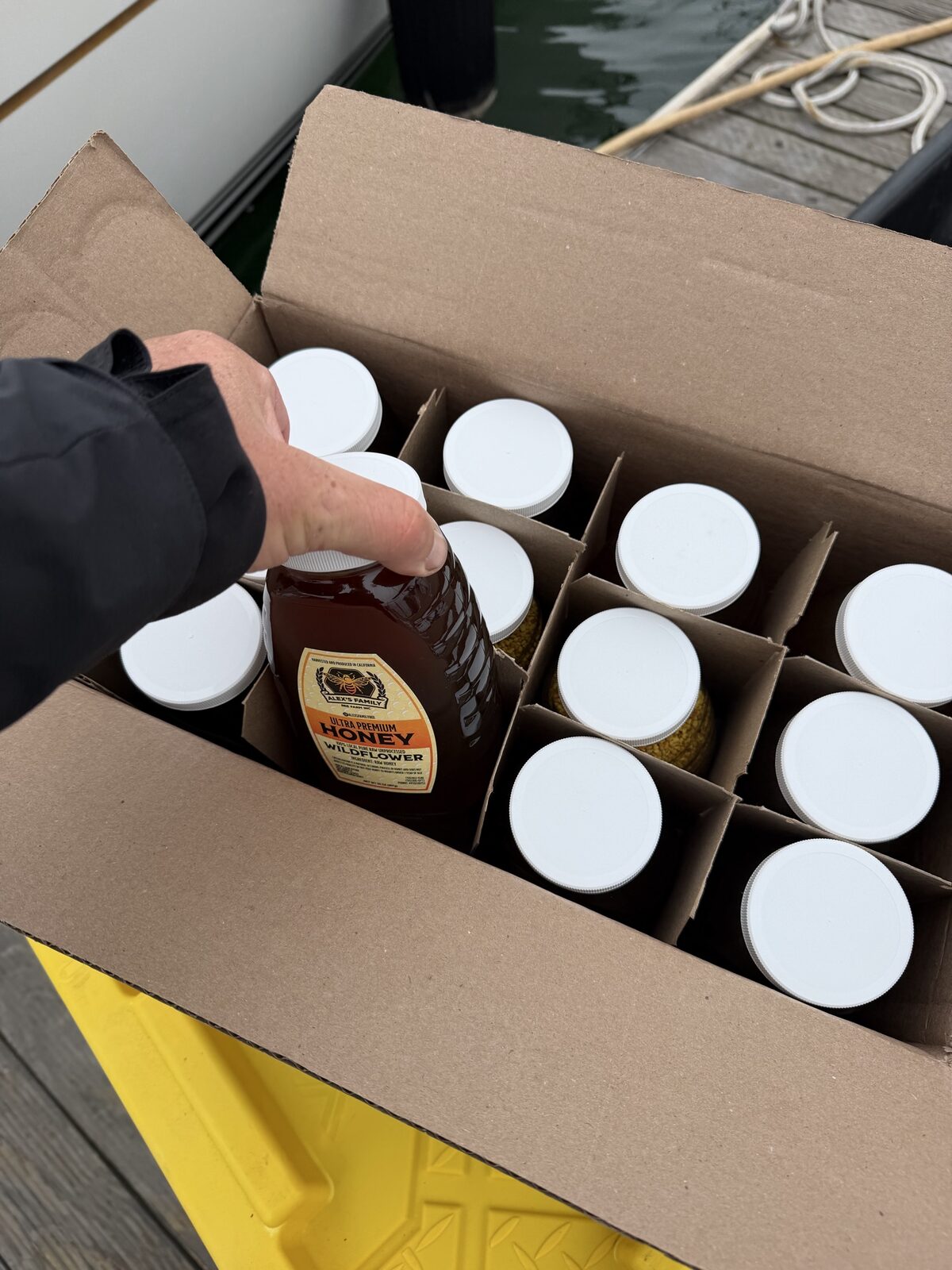 Case of wildflower honey jars on the dock next to SV Alruna